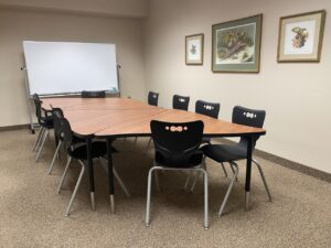 Room with table and chair and a white board.