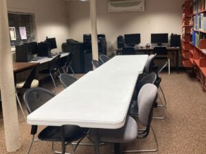 Room with tables and chairs and desktop computers.